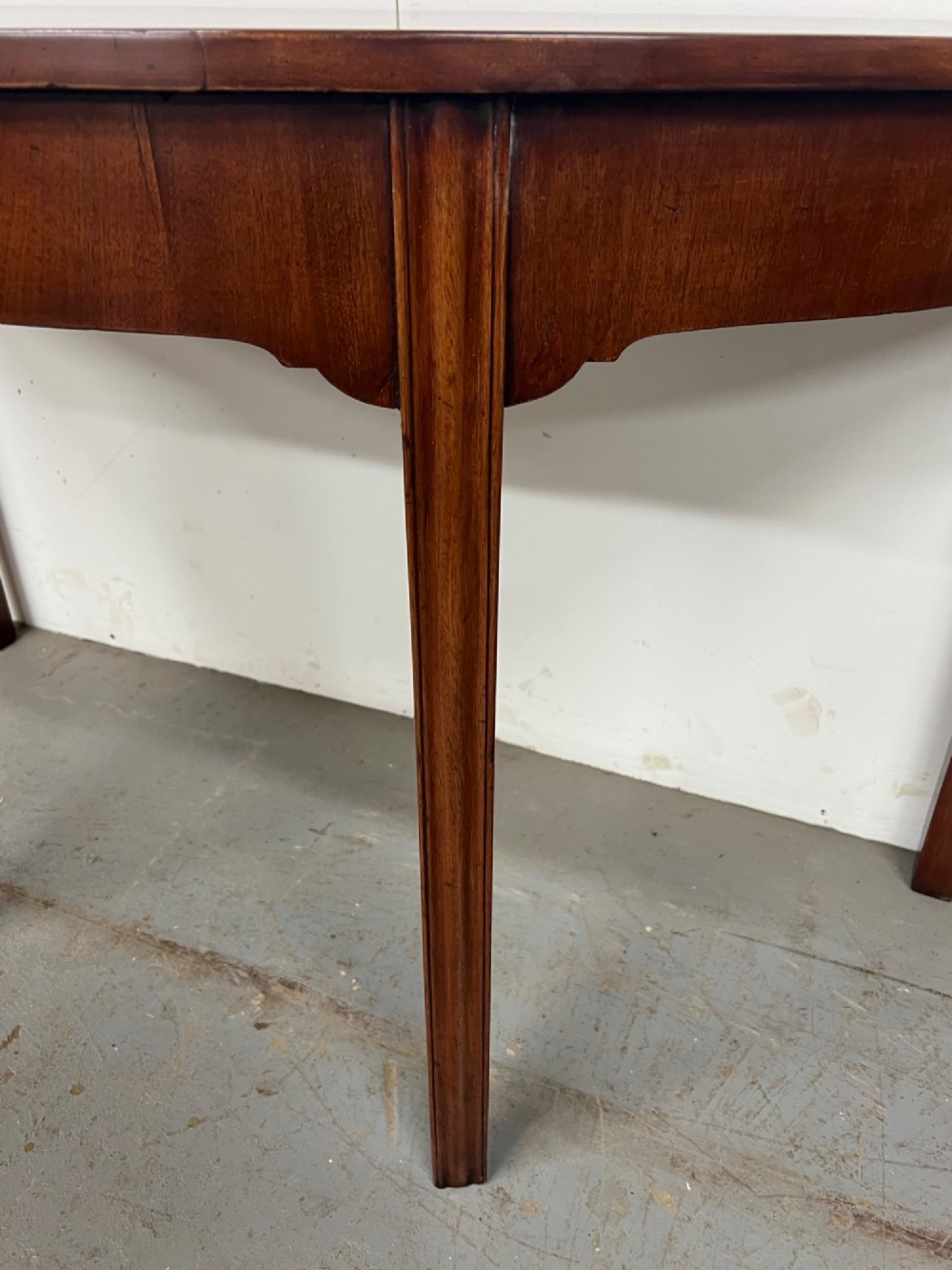 A pair of semi-circular George IV mahogany demilune console tables with polished surfaces and straight tapered legs. View V