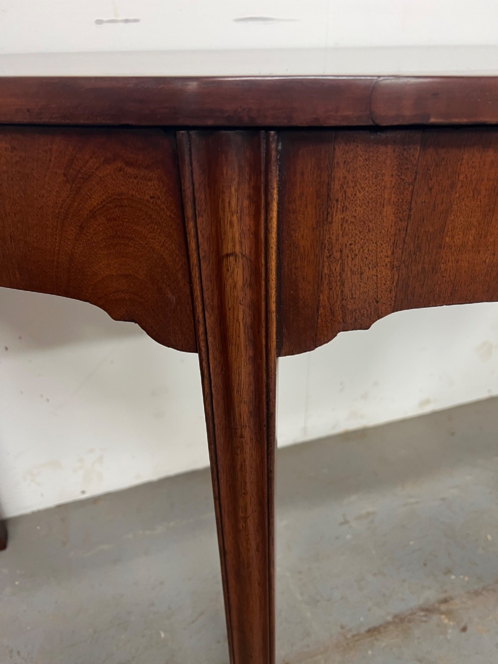A pair of semi-circular George IV mahogany demilune console tables with polished surfaces and straight tapered legs. View VI