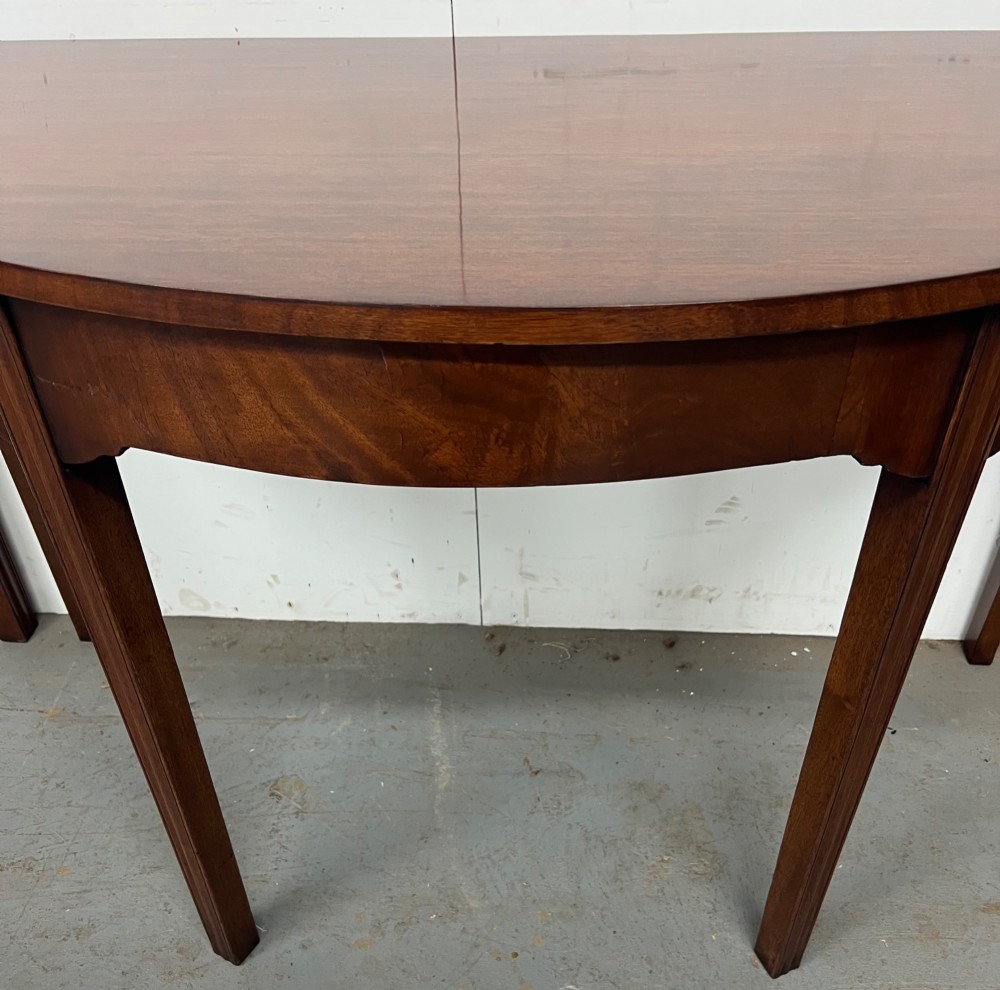 A pair of semi-circular George IV mahogany demilune console tables with polished surfaces and straight tapered legs. View VII