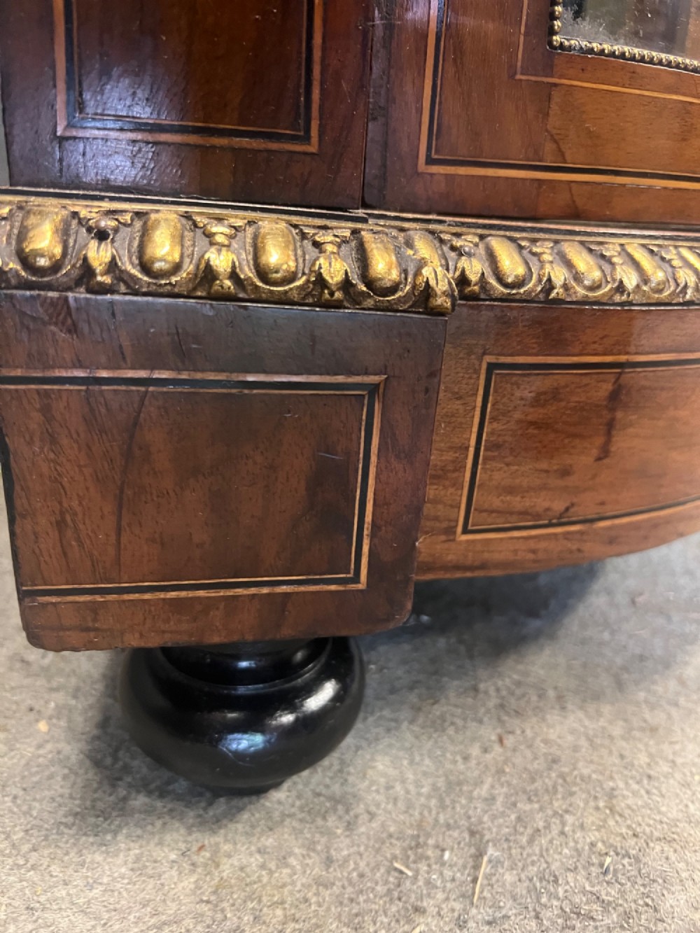 A Victorian credenza crafted from burr walnut with floral marquetry inlay, a central panelled cupboard door, curved glass display bays, and ornate ormolu mounts. View X