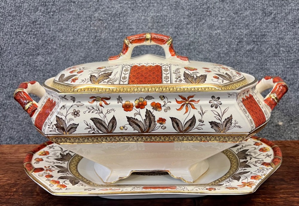 A fifty-nine piece Victorian earthenware dinner service decorated in rust orange, brown floral transfer patterns, and gilt accents arranged on a dark wood surface. View IV
