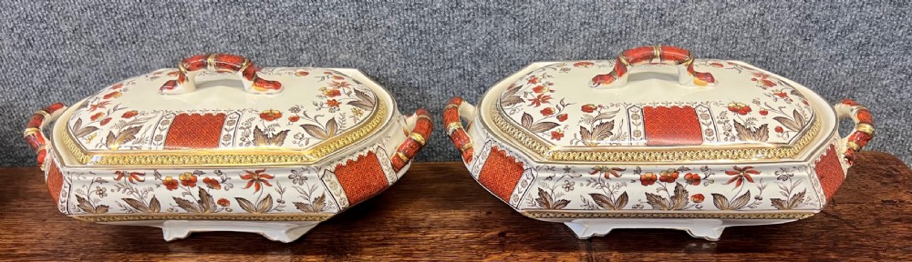 A fifty-nine piece Victorian earthenware dinner service decorated in rust orange, brown floral transfer patterns, and gilt accents arranged on a dark wood surface. View V