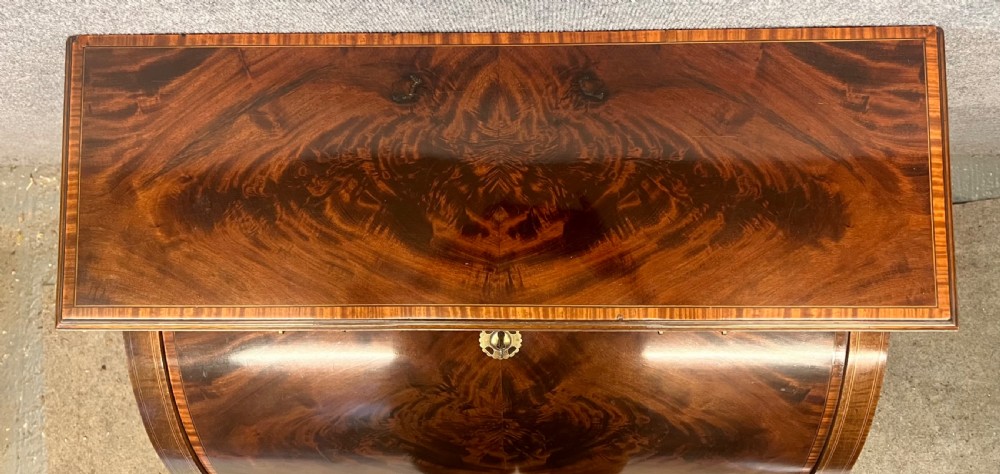 An Edwardian Sheraton Revival mahogany and satinwood cylinder ladies desk featuring crossbanded marquetry, brass drop handles, square tapered legs, and castors. View VIII