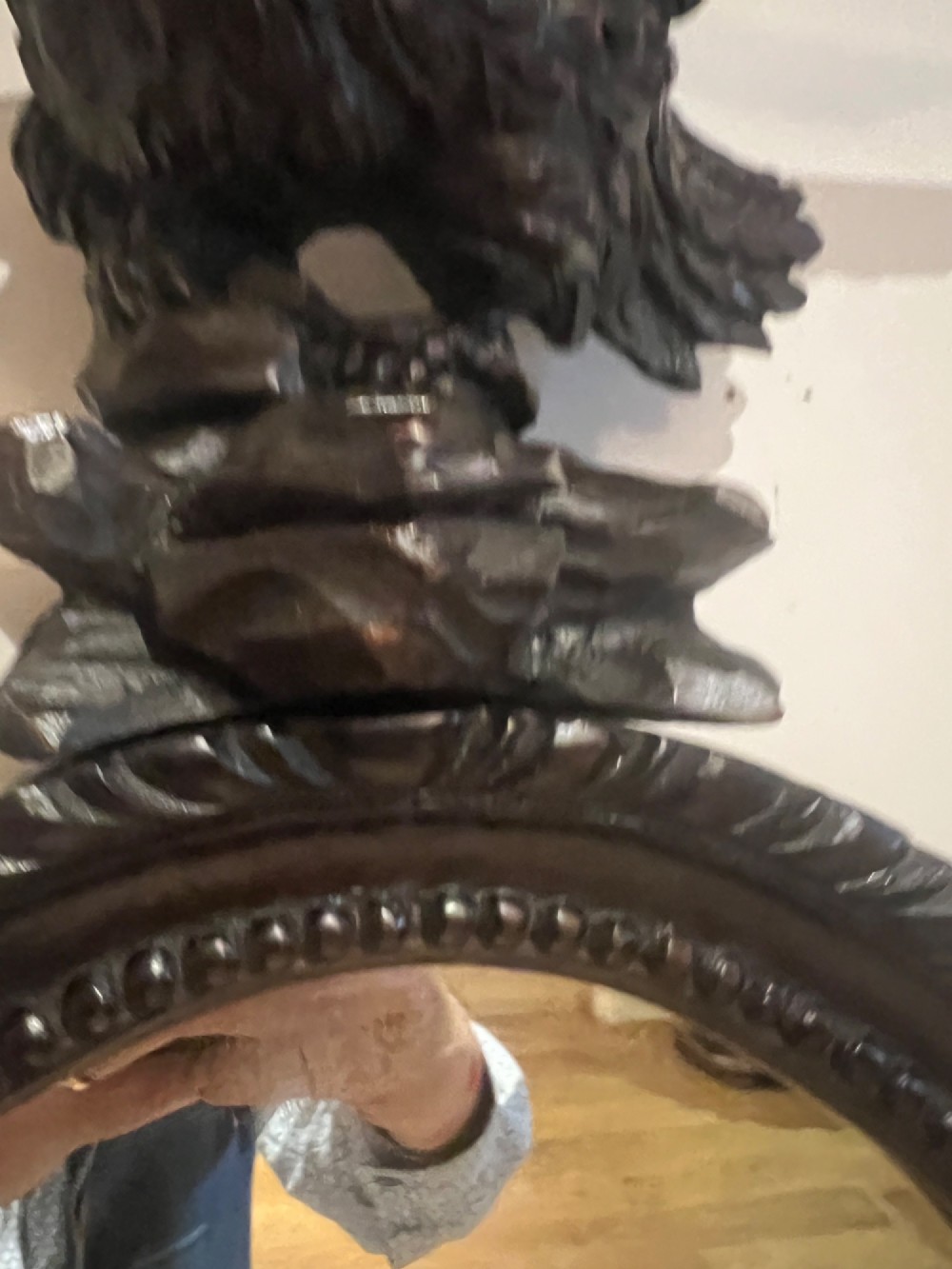 A dark stained oval wooden wall mirror featuring a carved eagle with spread wings perched atop a frame decorated with beaded and rope-twist detailing. View VII