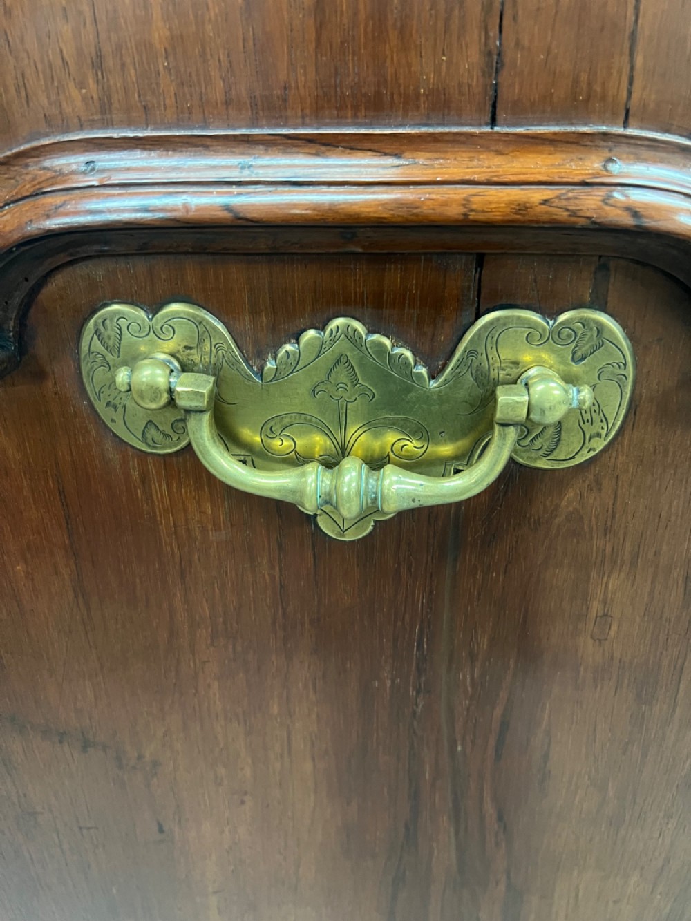 An 18th-century dark rosewood slant-front bureau shown open, featuring a stepped fitted interior, brass drop handles, and three long drawers below. View IV