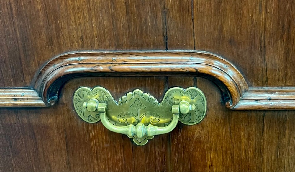 An 18th-century dark rosewood slant-front bureau shown open, featuring a stepped fitted interior, brass drop handles, and three long drawers below. View VI