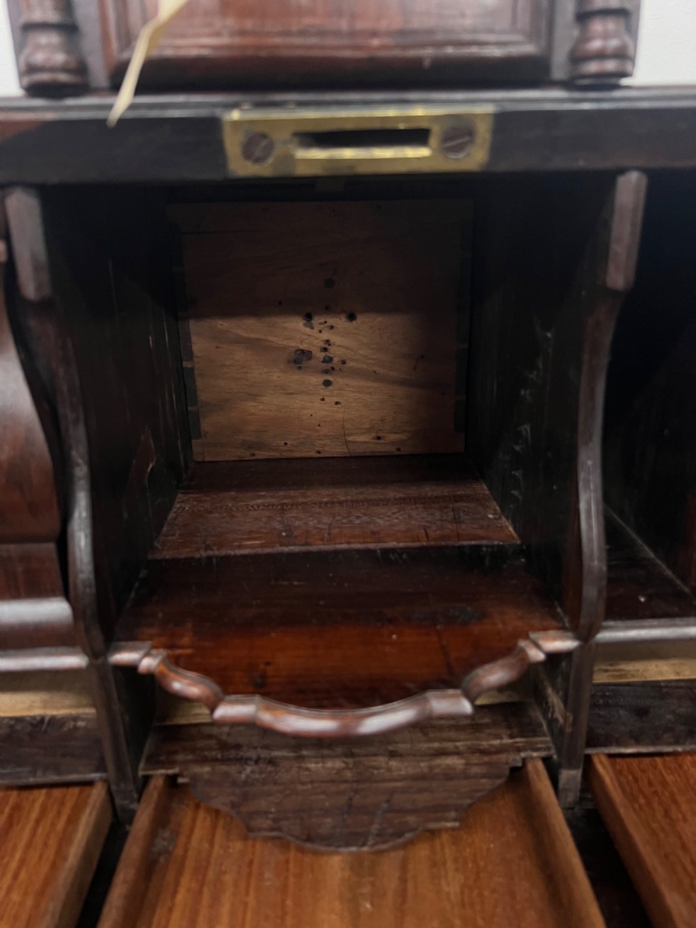 An 18th-century dark rosewood slant-front bureau shown open, featuring a stepped fitted interior, brass drop handles, and three long drawers below. View X