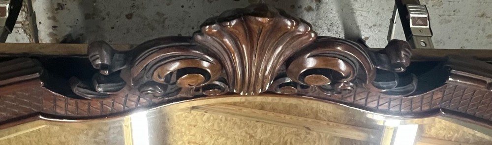 A large horizontal oval wall mirror with a dark carved wood frame featuring a central shell crest and cross-hatched border pattern. View II