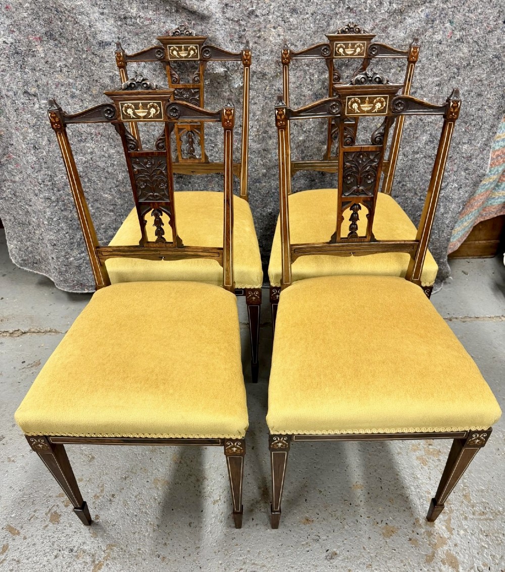 A set of four late Victorian inlaid rosewood side chairs featuring carved back splats with urn marquetry and yellow upholstered seats.