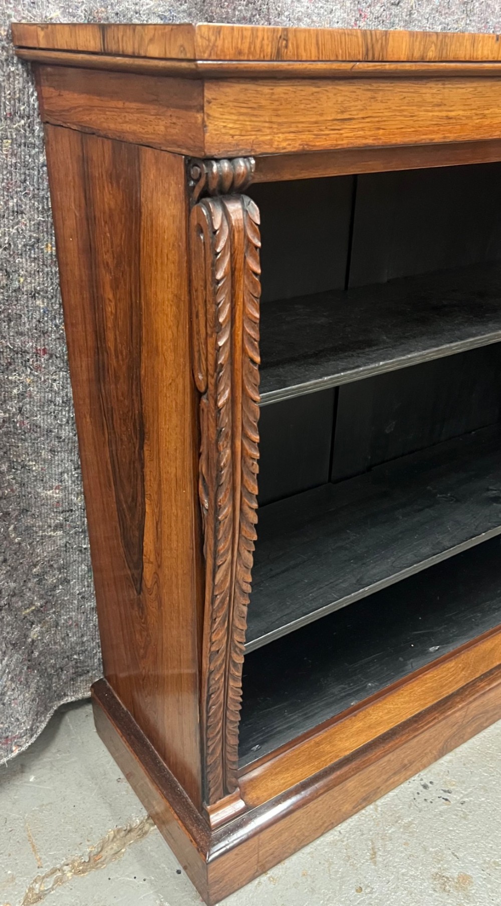A low Regency open bookcase crafted from dark polished wood featuring carved twist mouldings on the side columns and three open shelves above a solid plinth base. View VIII