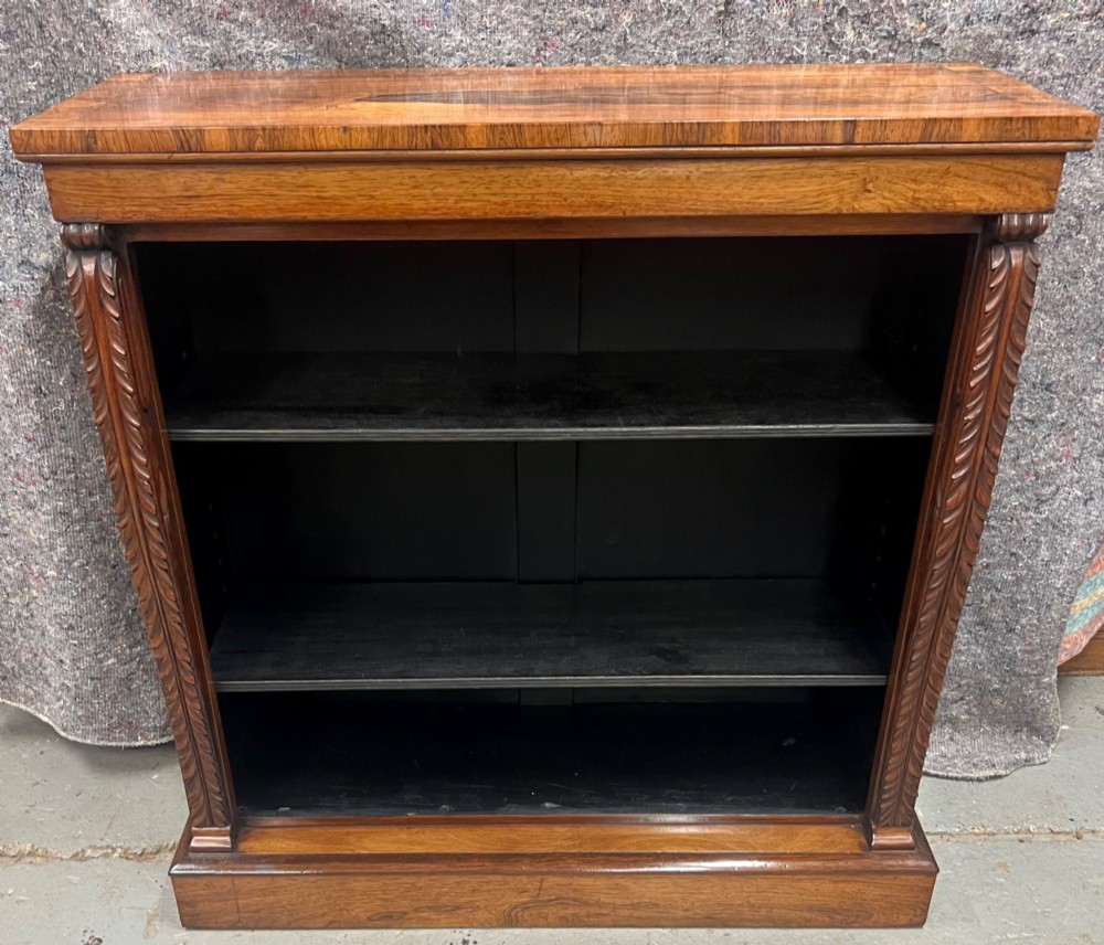 A low Regency open bookcase crafted from dark polished wood featuring carved twist mouldings on the side columns and three open shelves above a solid plinth base. View X