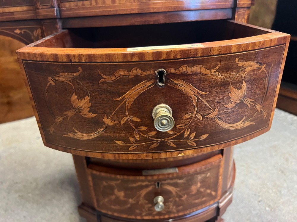 An Edwardian mahogany kidney-shaped desk featuring detailed floral marquetry inlay, a tooled leather writing surface, multiple drawers, and brass castors. View VIII