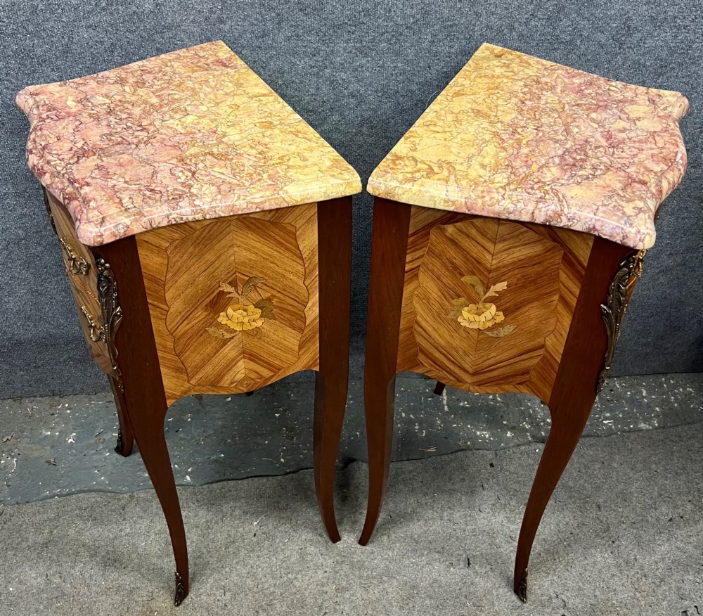 A pair of French Louis XV style bedside chests featuring floral marquetry inlay, curved cabriole legs, decorative metal mounts, and shaped pink marble tops. View III