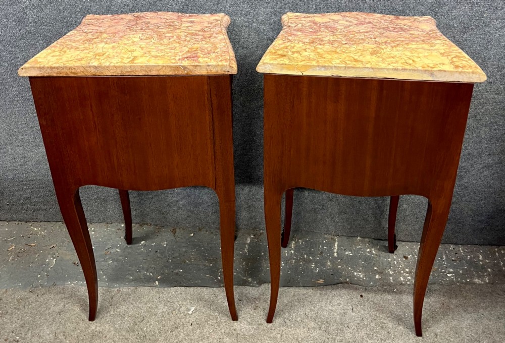 A pair of French Louis XV style bedside chests featuring floral marquetry inlay, curved cabriole legs, decorative metal mounts, and shaped pink marble tops. View V