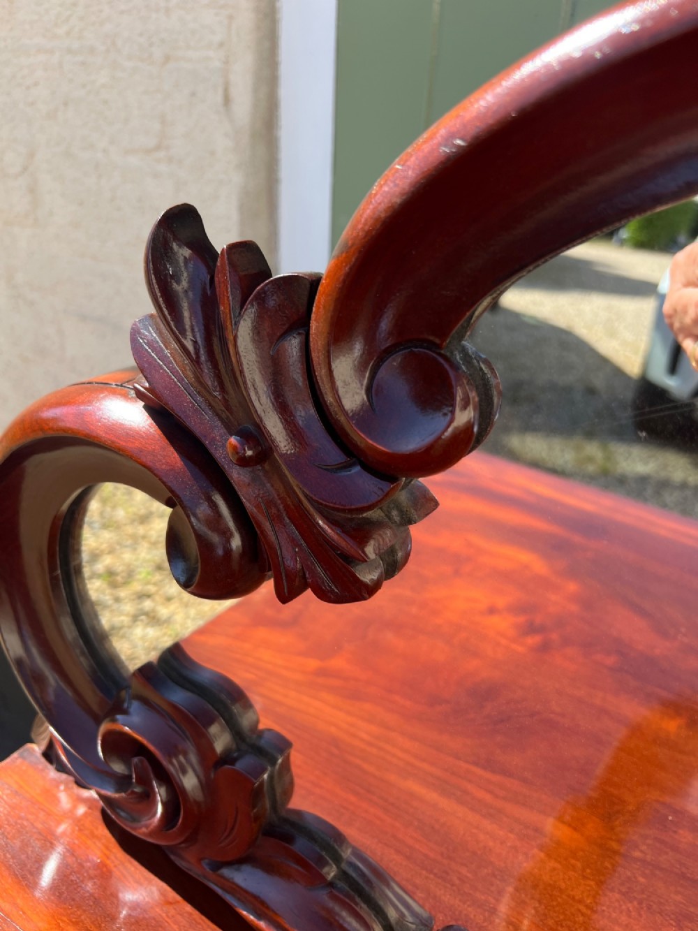 A nineteenth-century mahogany sideboard featuring a large carved mirror frame upstand, central double cupboard doors, flanking side doors with scroll mouldings, and flame timber veneers. View V