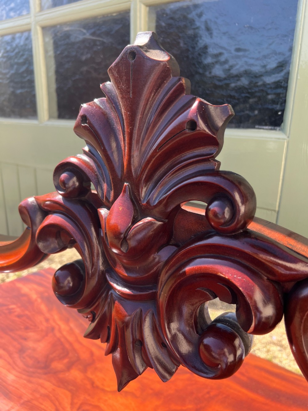 A nineteenth-century mahogany sideboard featuring a large carved mirror frame upstand, central double cupboard doors, flanking side doors with scroll mouldings, and flame timber veneers. View VII