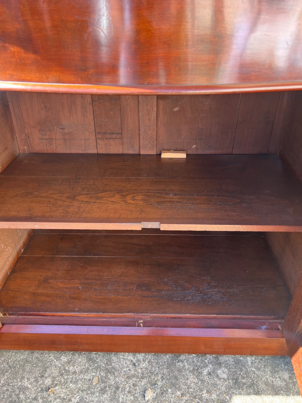 A nineteenth-century mahogany sideboard featuring a large carved mirror frame upstand, central double cupboard doors, flanking side doors with scroll mouldings, and flame timber veneers. View XIII