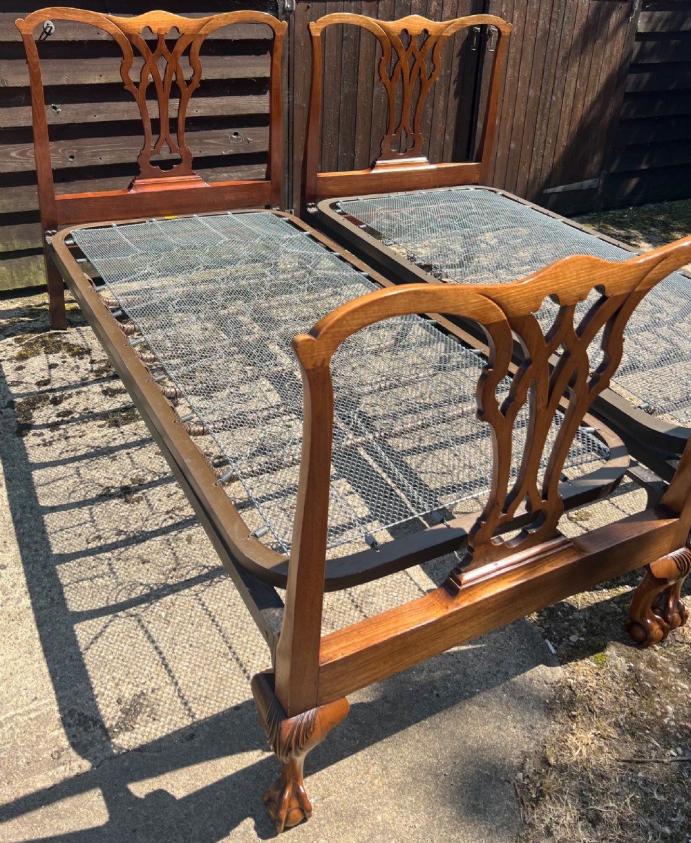 A pair of antique Chippendale style mahogany single bed frames featuring carved pierced back splats, yoke crest rails, and cabriole legs ending in claw and ball feet. View IV