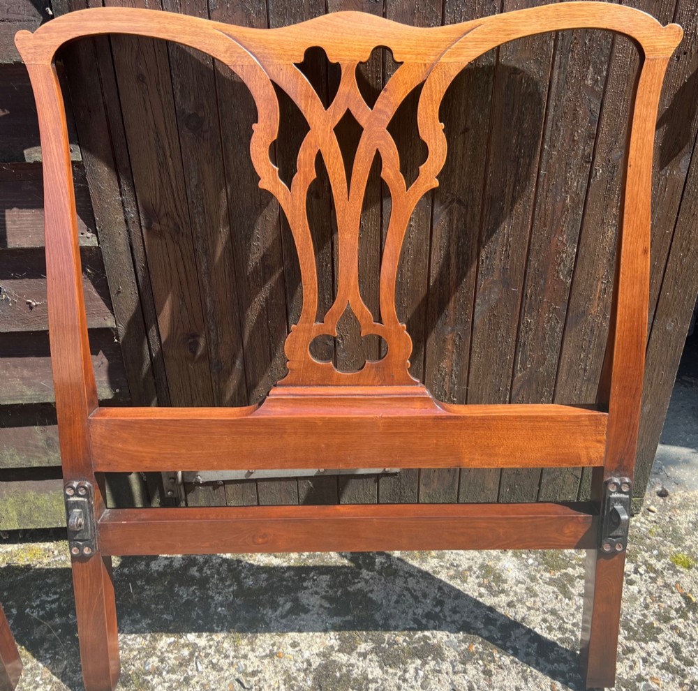 A pair of antique Chippendale style mahogany single bed frames featuring carved pierced back splats, yoke crest rails, and cabriole legs ending in claw and ball feet. View V