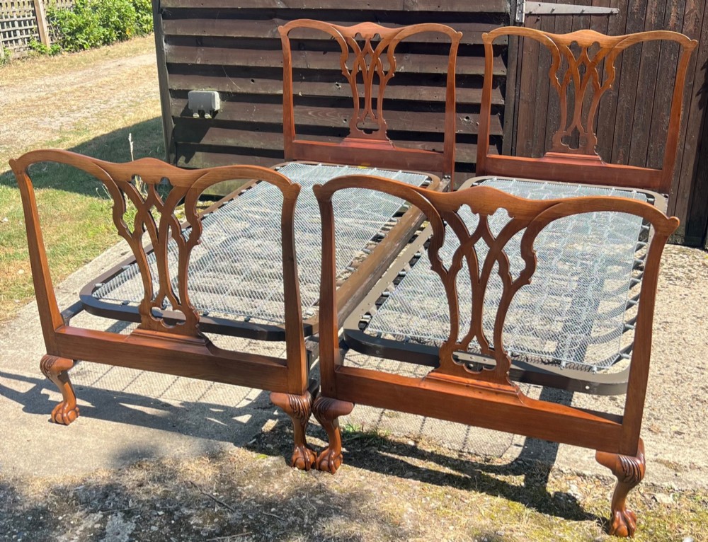 A pair of antique Chippendale style mahogany single bed frames featuring carved pierced back splats, yoke crest rails, and cabriole legs ending in claw and ball feet. View VIII