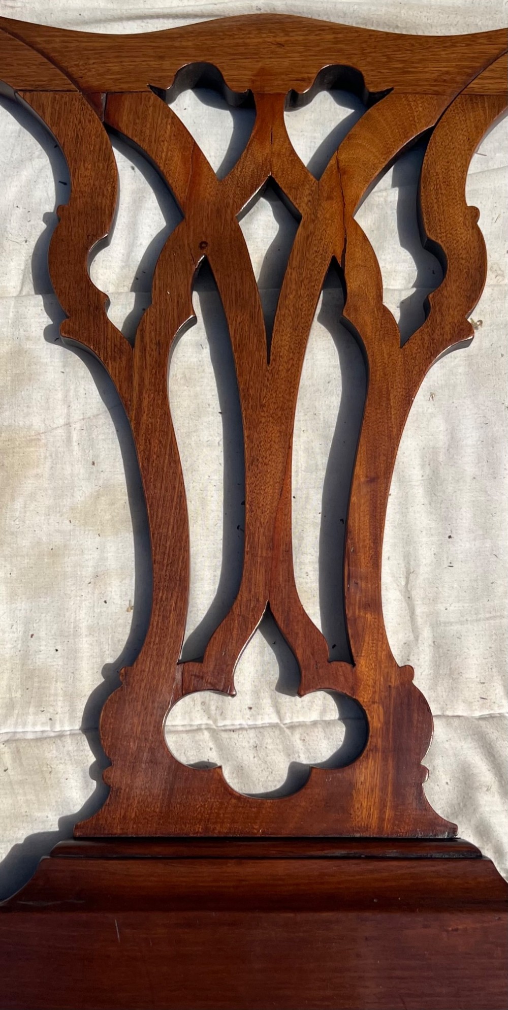 A pair of antique Chippendale style mahogany single bed frames featuring carved pierced back splats, yoke crest rails, and cabriole legs ending in claw and ball feet. View IX
