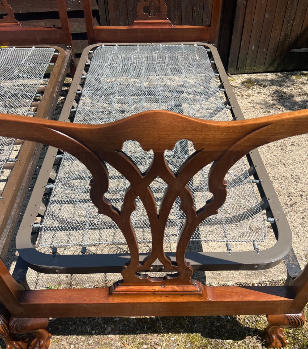 A pair of antique Chippendale style mahogany single bed frames featuring carved pierced back splats, yoke crest rails, and cabriole legs ending in claw and ball feet. View XII