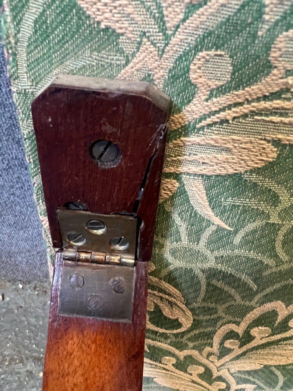 A Victorian campaign adjustable wooden backrest frame upholstered in patterned green fabric with notched timber ratchets for support. View IV