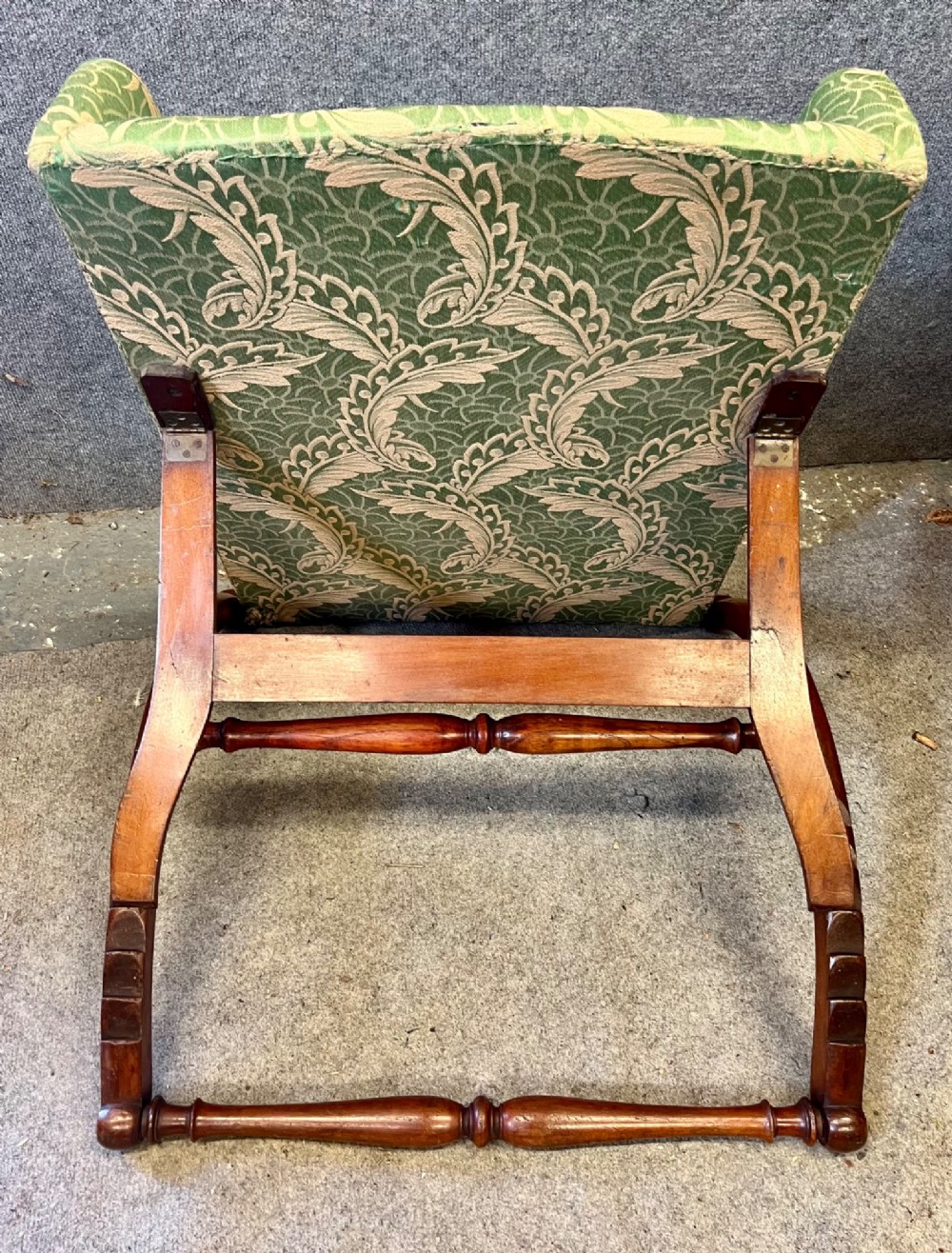 A Victorian campaign adjustable wooden backrest frame upholstered in patterned green fabric with notched timber ratchets for support. View VI