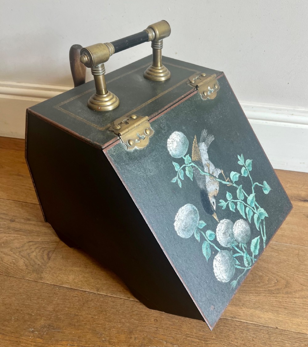 An antique dark green toleware coal scuttle featuring a slant front with a hand-painted bird and floral motif, brass hinges, and a brass top handle. View II