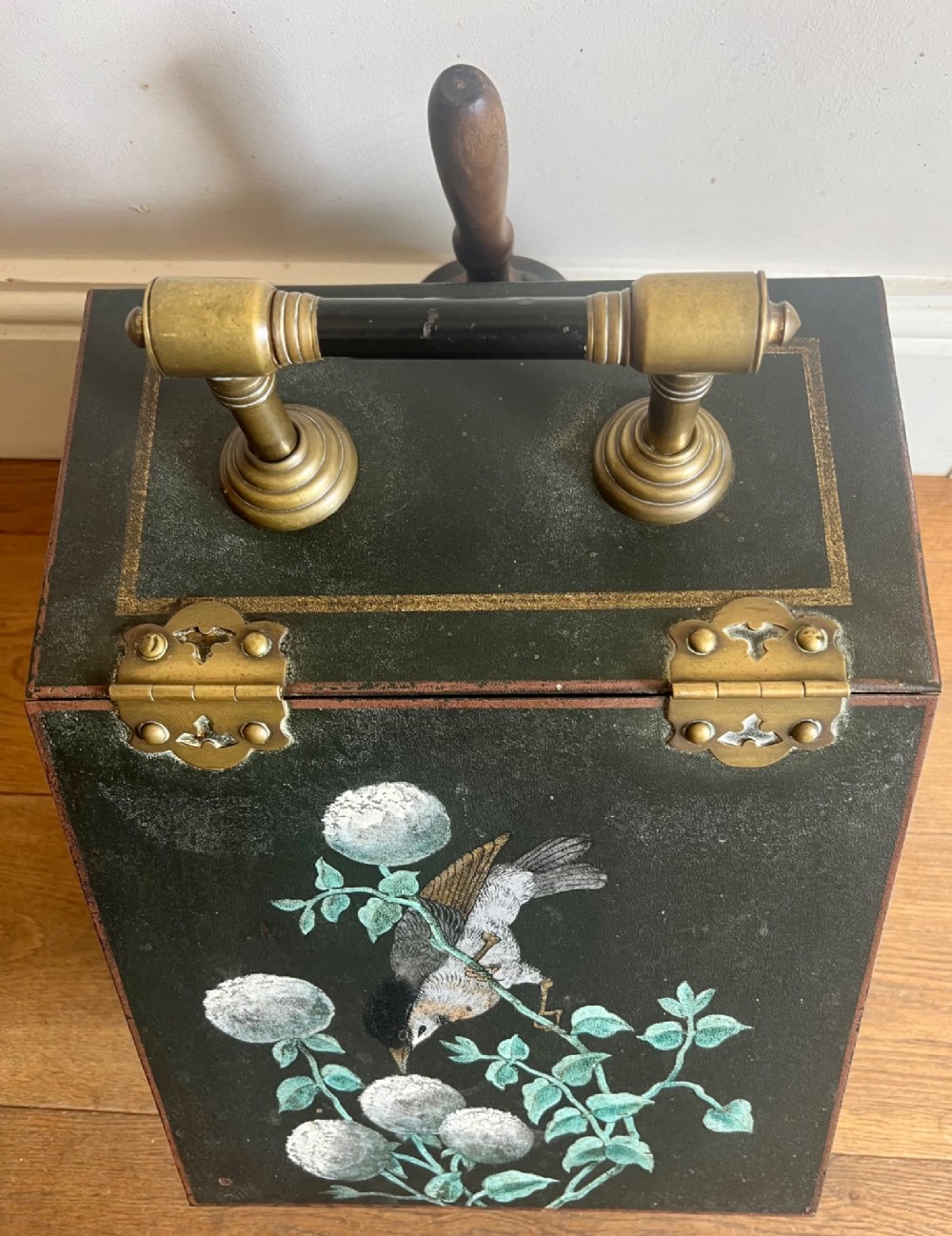 An antique dark green toleware coal scuttle featuring a slant front with a hand-painted bird and floral motif, brass hinges, and a brass top handle. View III