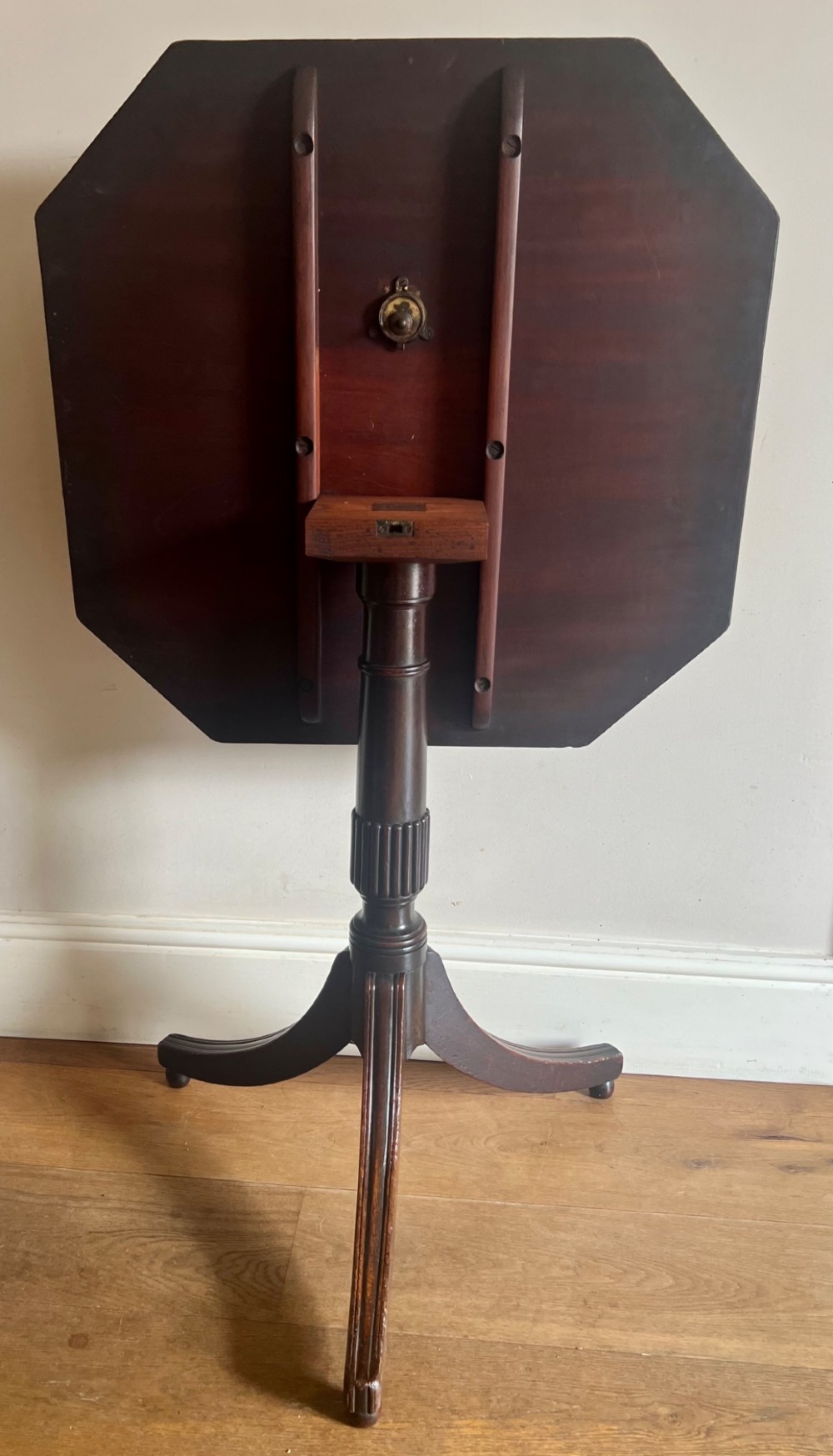 A George III mahogany tilt-top table featuring an octagonal top set on a reeded turned column and a splayed tripod base. View III