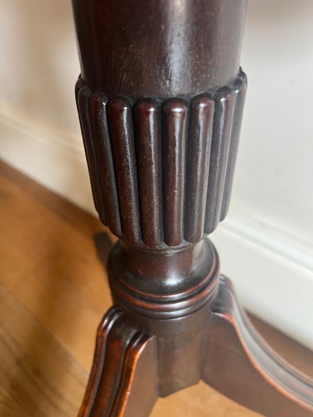 A George III mahogany tilt-top table featuring an octagonal top set on a reeded turned column and a splayed tripod base. View VI