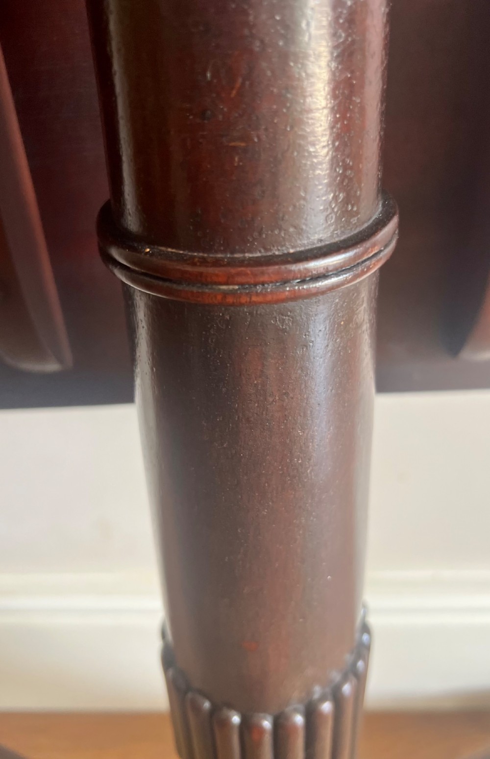A George III mahogany tilt-top table featuring an octagonal top set on a reeded turned column and a splayed tripod base. View IX
