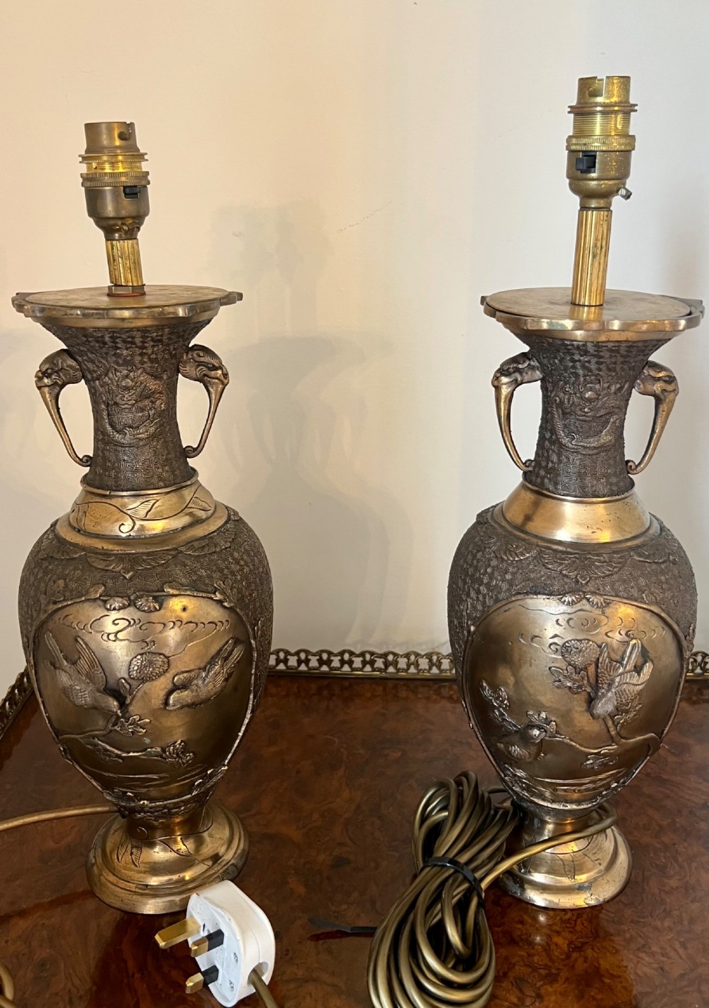 A pair of Japanese Meiji period bronze vase table lamps featuring relief bird and botanical motifs with pleated cream fabric lampshades. View IV