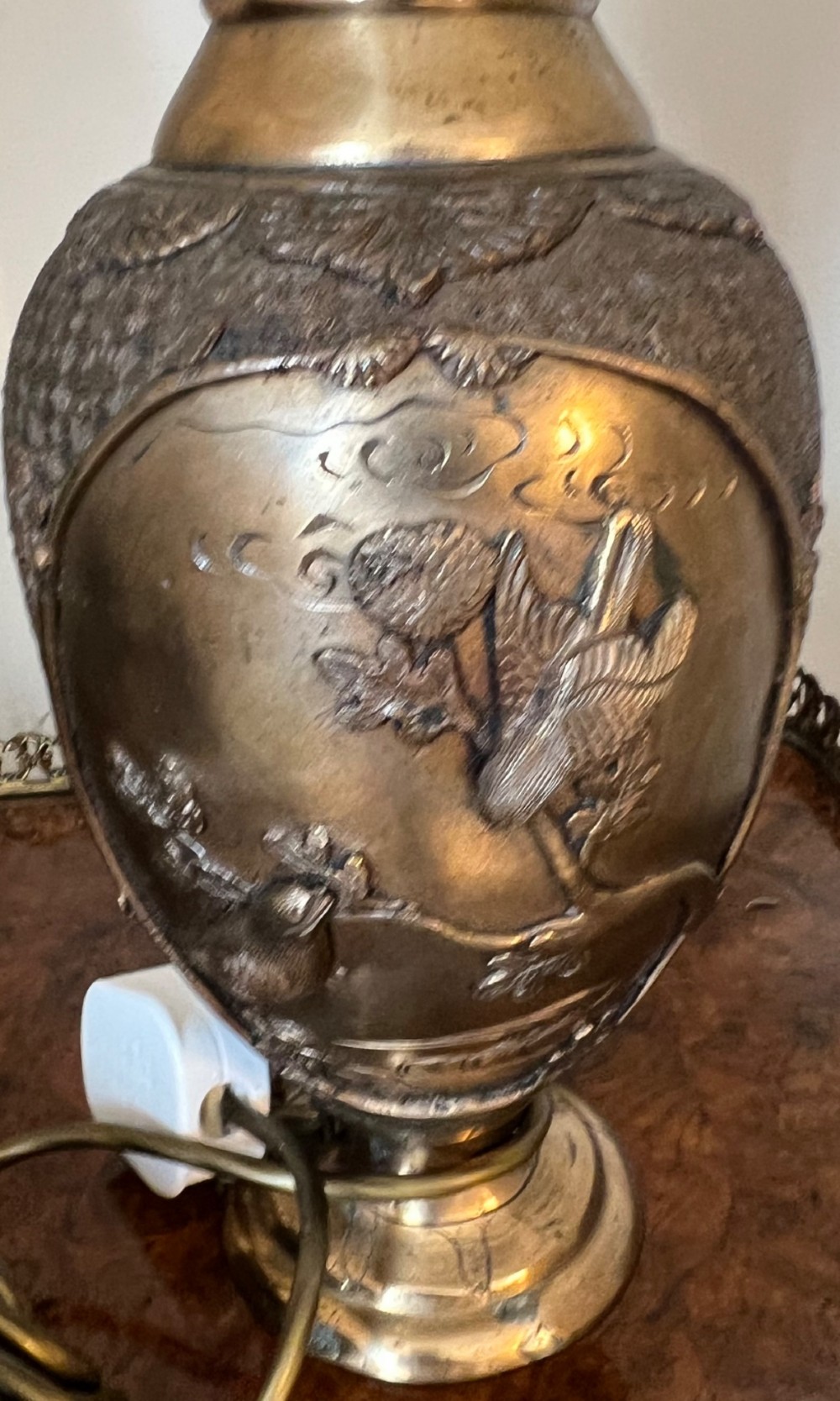 A pair of Japanese Meiji period bronze vase table lamps featuring relief bird and botanical motifs with pleated cream fabric lampshades. View V