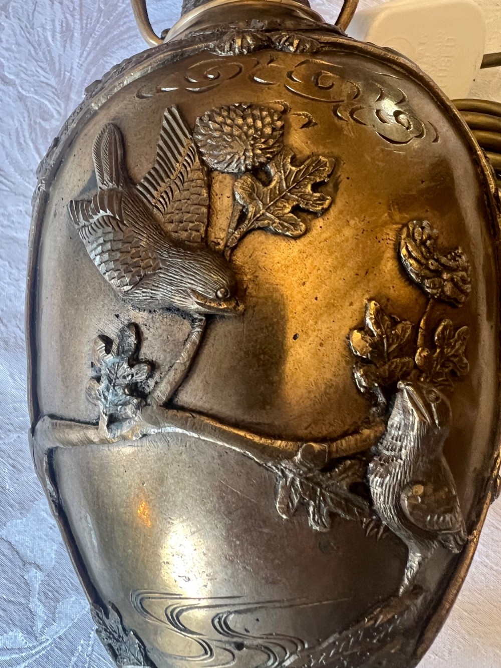 A pair of Japanese Meiji period bronze vase table lamps featuring relief bird and botanical motifs with pleated cream fabric lampshades. View XII