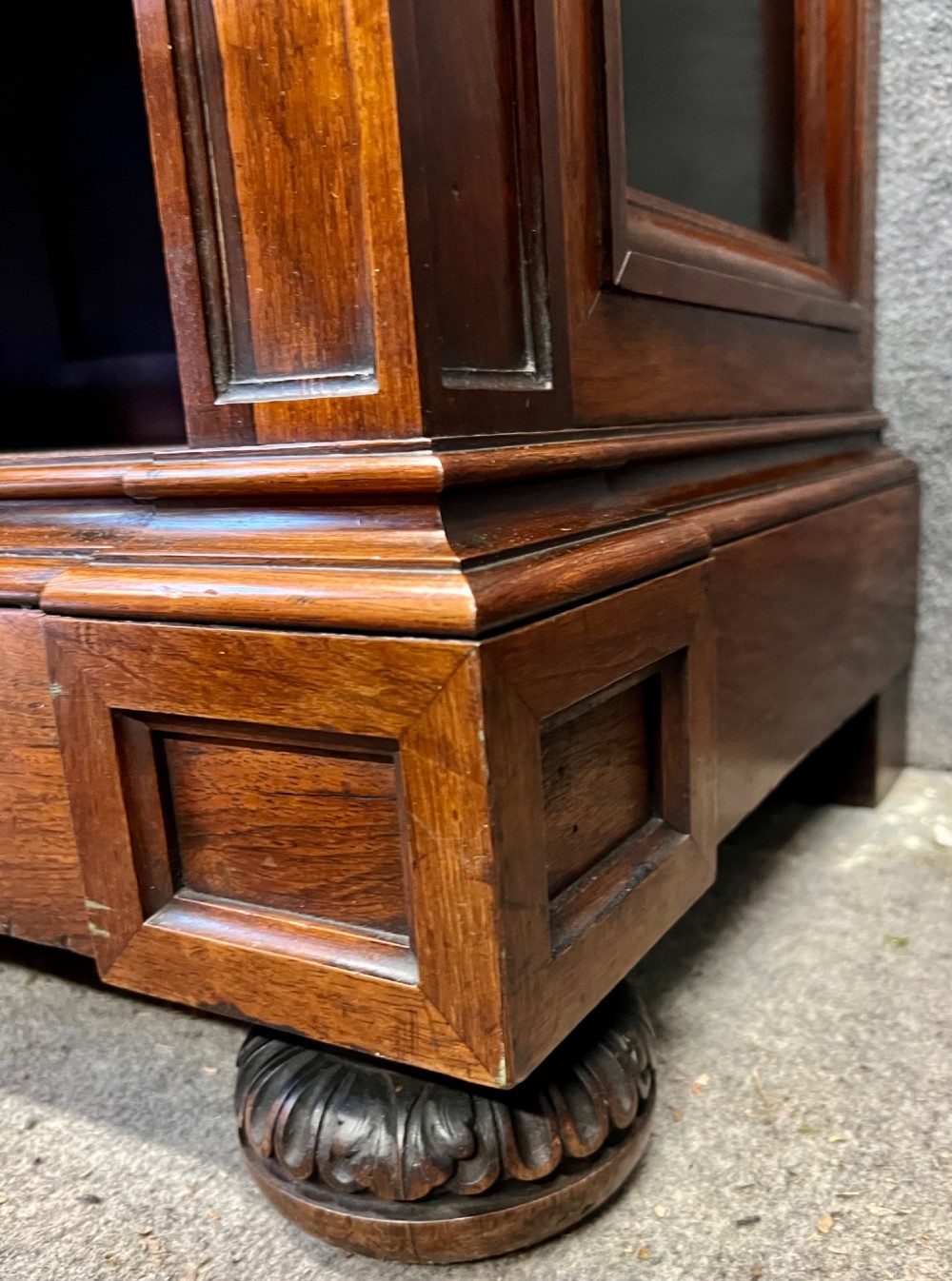 A Victorian dark walnut open bookcase with two carved drawers, open shelves, fluted pilasters, and a decorative pediment top featuring a central urn finial. View V