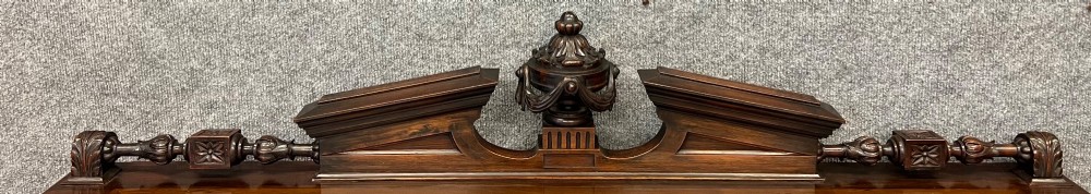 A Victorian dark walnut open bookcase with two carved drawers, open shelves, fluted pilasters, and a decorative pediment top featuring a central urn finial. View XII