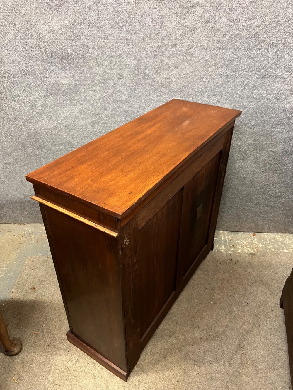 A small Victorian mahogany low bookcase featuring two glazed doors with arched frames, brass knobs, internal timber shelving, and a plinth base. View IV