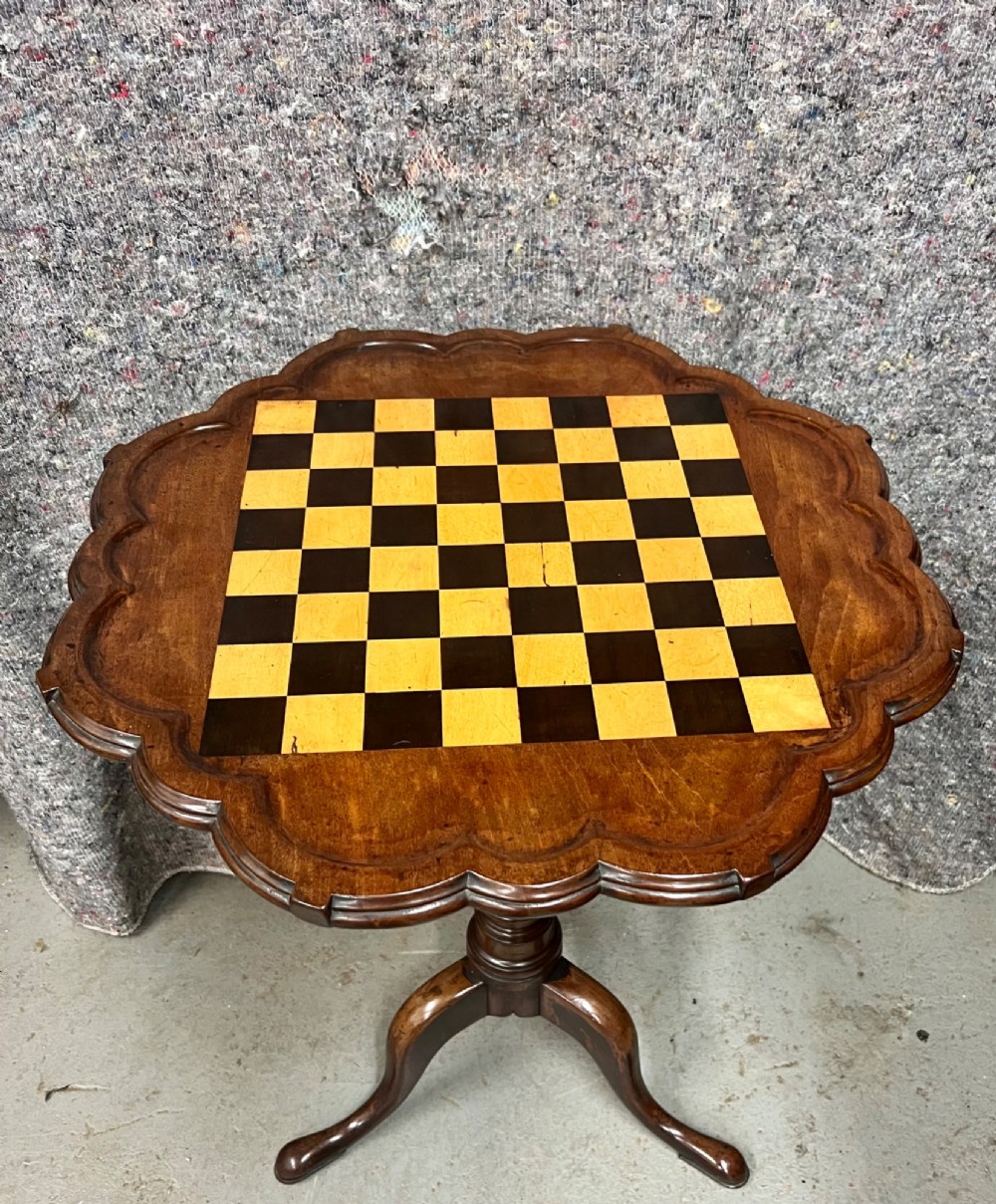 A George III mahogany tripod table featuring a scalloped piecrust rim, an inlaid chessboard top, a turned pedestal, and three cabriole legs. View II
