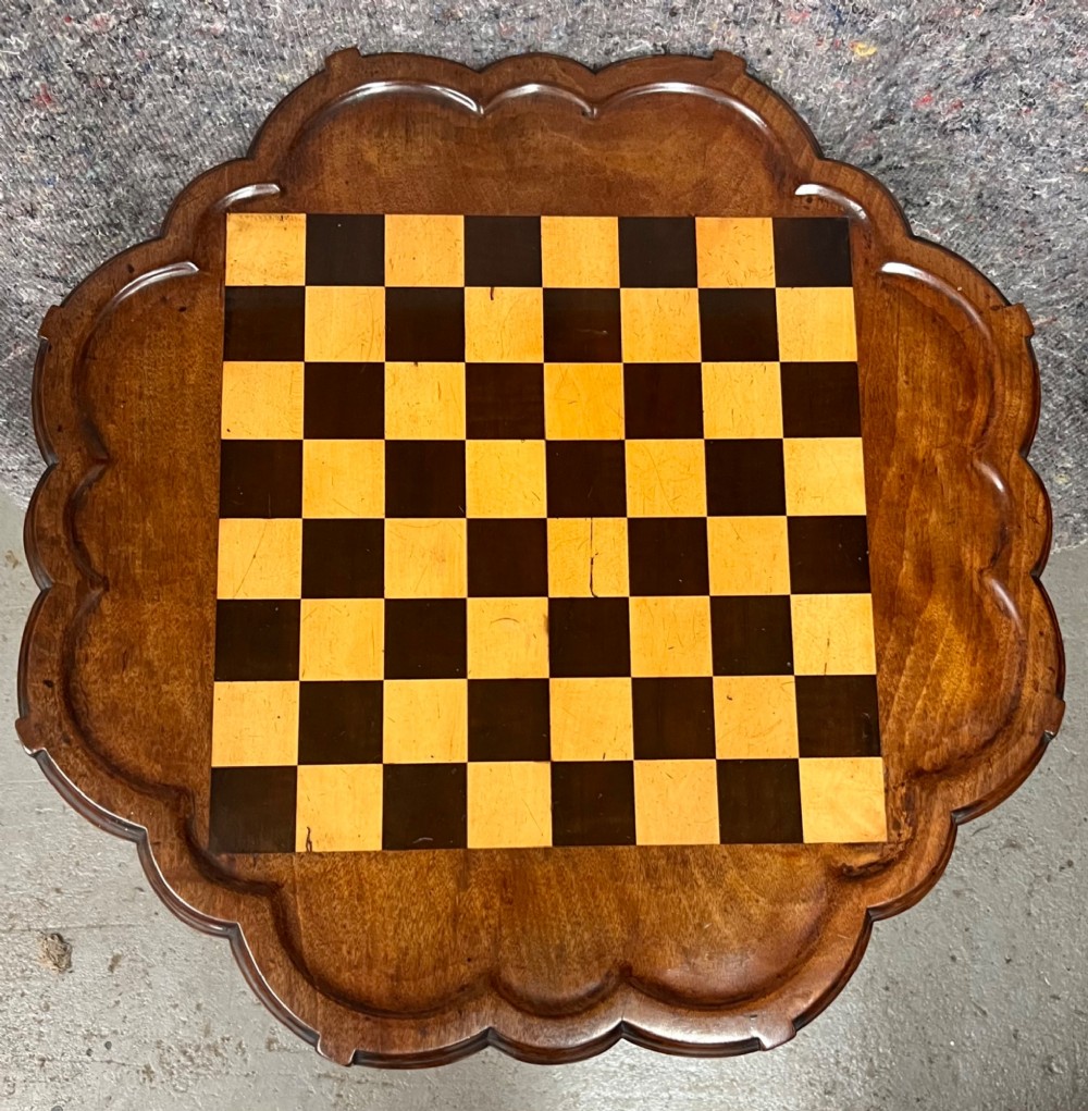 A George III mahogany tripod table featuring a scalloped piecrust rim, an inlaid chessboard top, a turned pedestal, and three cabriole legs. View IV