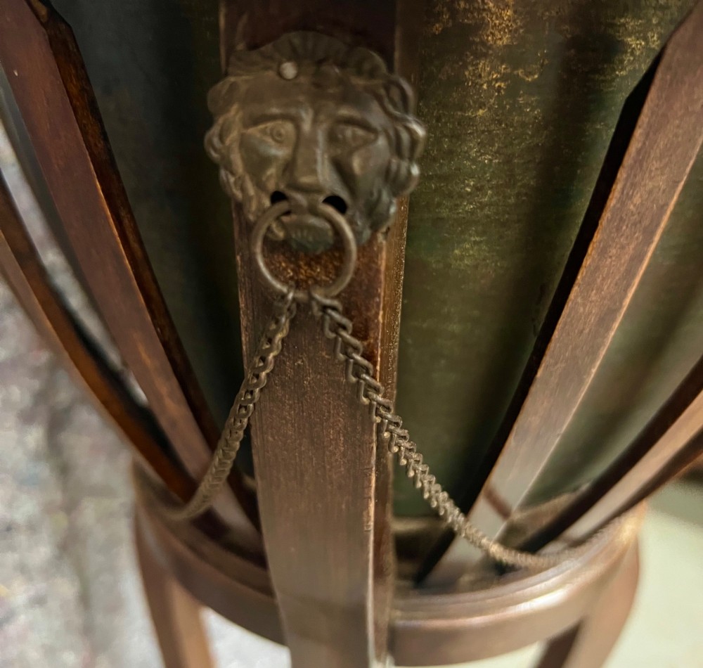 An Edwardian mahogany jardiniere plant stand featuring a slatted circular bucket with internal metal lining, supported by three curved legs and a triangular base stretcher. View II