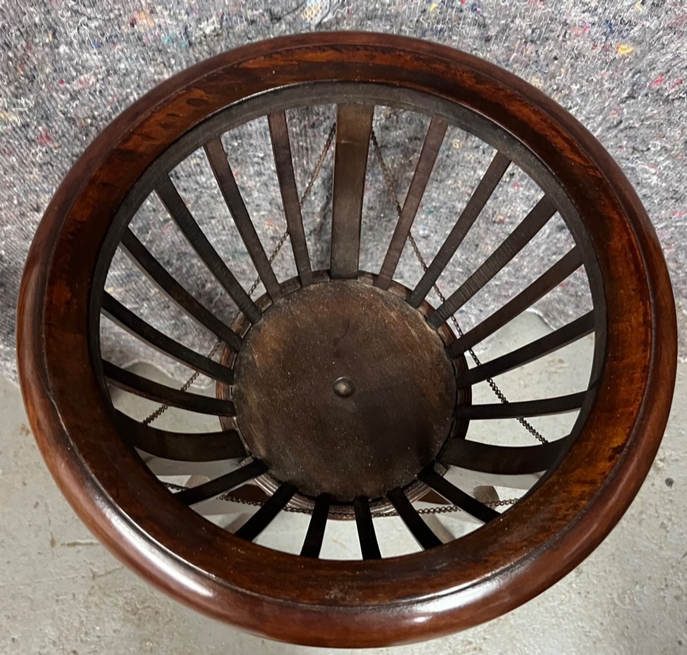 An Edwardian mahogany jardiniere plant stand featuring a slatted circular bucket with internal metal lining, supported by three curved legs and a triangular base stretcher. View IV