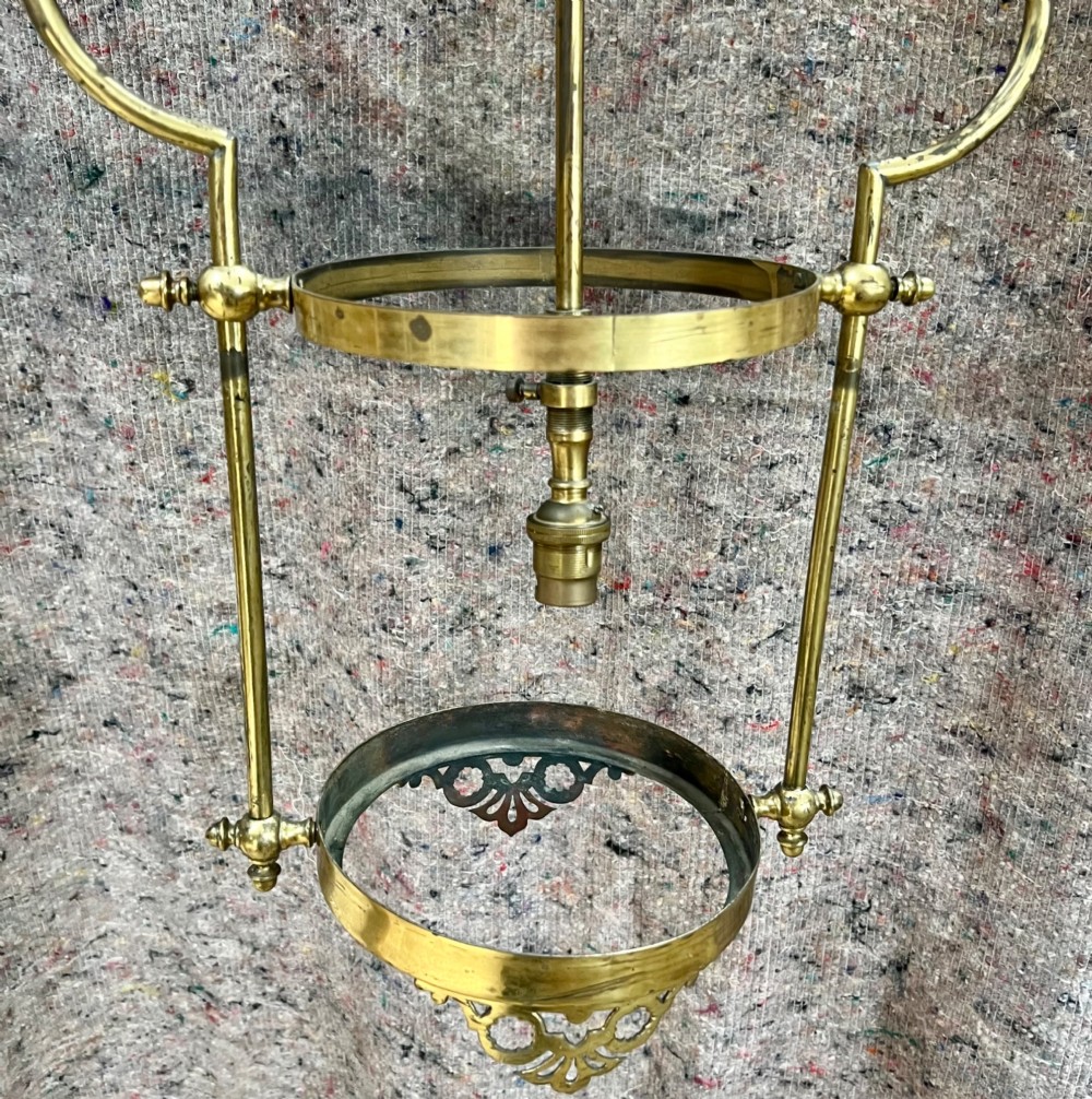An antique brass hanging pendant lantern featuring a contoured brass frame suspending a moulded pink and amber glass shade. View VI