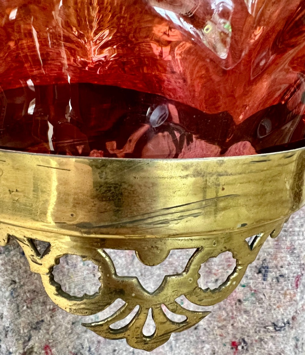 An antique brass hanging pendant lantern featuring a contoured brass frame suspending a moulded pink and amber glass shade. View VIII