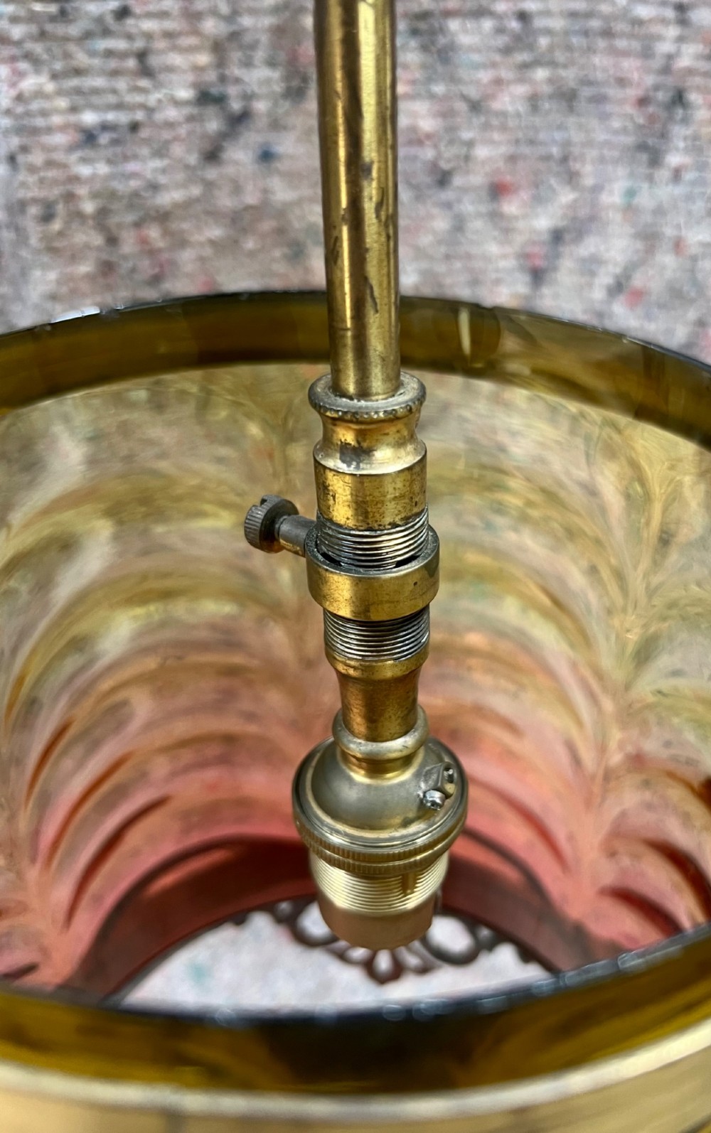 An antique brass hanging pendant lantern featuring a contoured brass frame suspending a moulded pink and amber glass shade. View XI