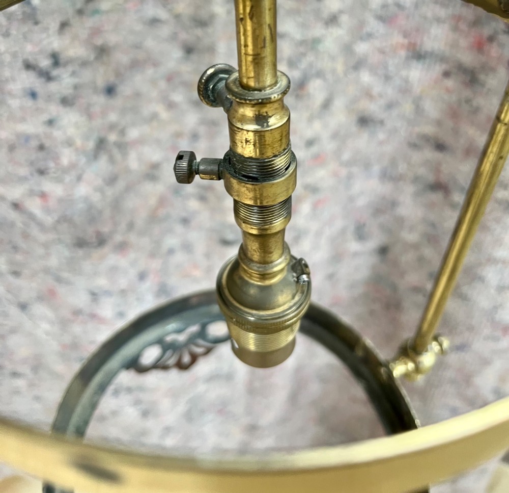 An antique brass hanging pendant lantern featuring a contoured brass frame suspending a moulded pink and amber glass shade. View XII