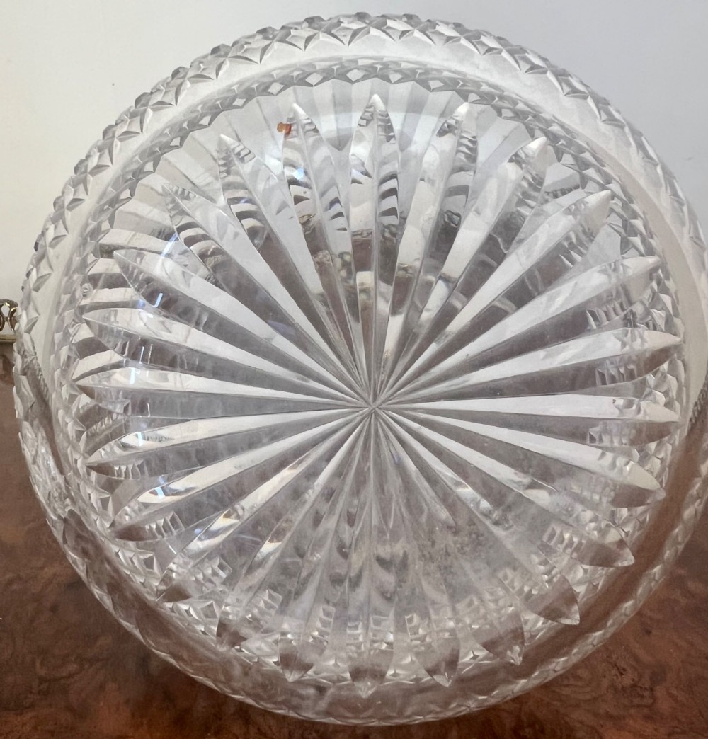 An Edwardian clear cut glass claret jug featuring a diamond-cut pattern body, an elongated handle, and a faceted spherical stopper. View IV