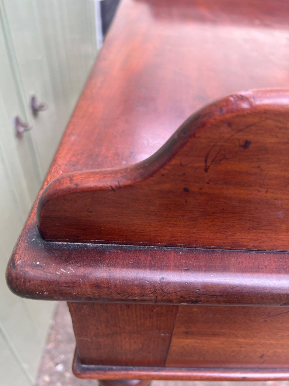 A nineteenth-century mahogany side table with a low gallery back, two frieze drawers, and turned reeded legs on brass castors. View X