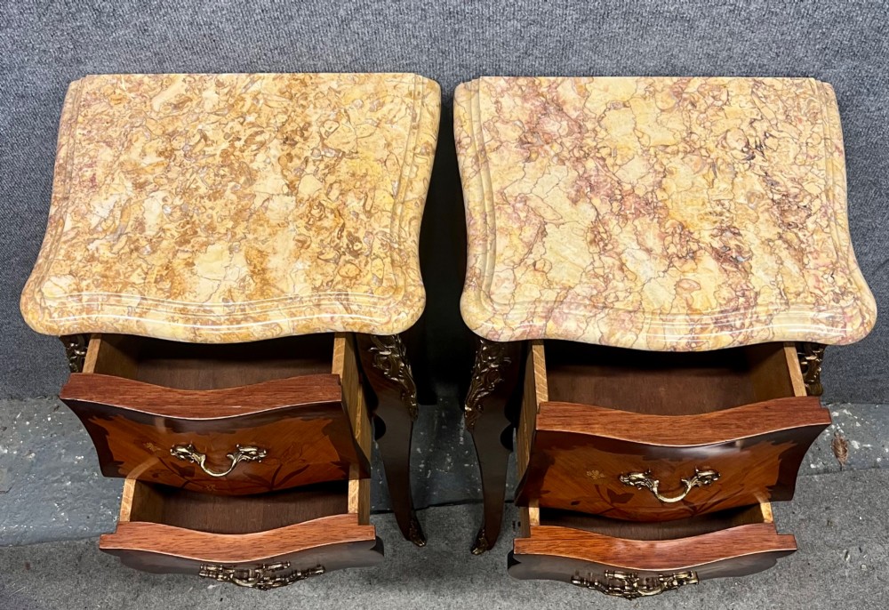A pair of French Louis XV style bedside tables featuring marble tops, two floral marquetry drawers, gilt-bronze mounts, and slender cabriole legs. View II